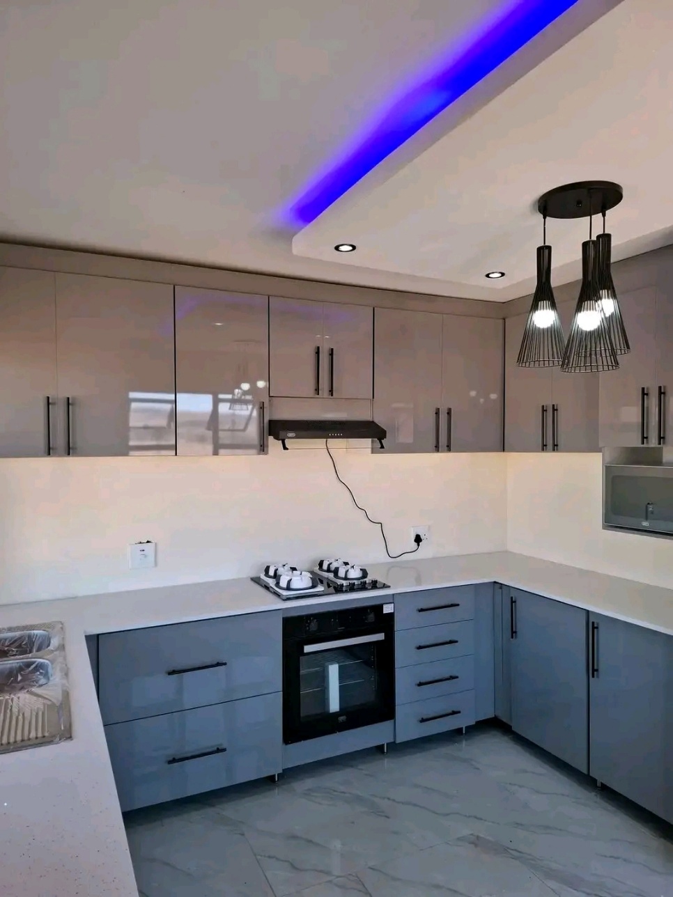 Modern kitchen with LED cove lighting and gloss cabinetry