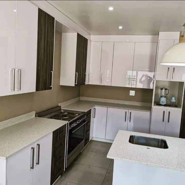 Two-tone modern kitchen with breakfast bar and gas hob