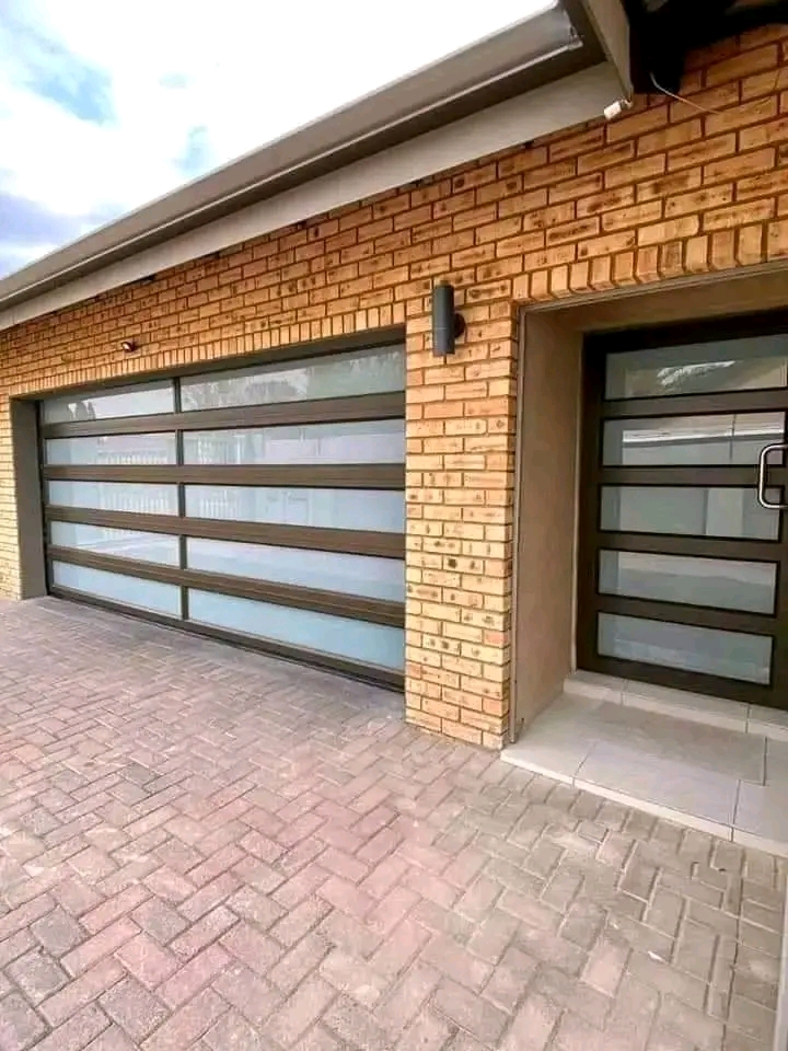 Modern double garage with glass-panel doors and face brick