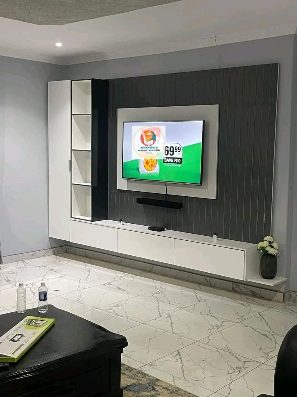 Built-in white TV wall unit with marble feature and slatted panels