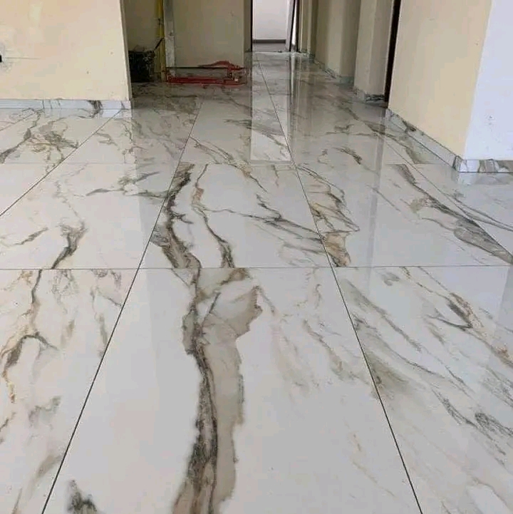 High-gloss marble floor tile installation in a residential hallway