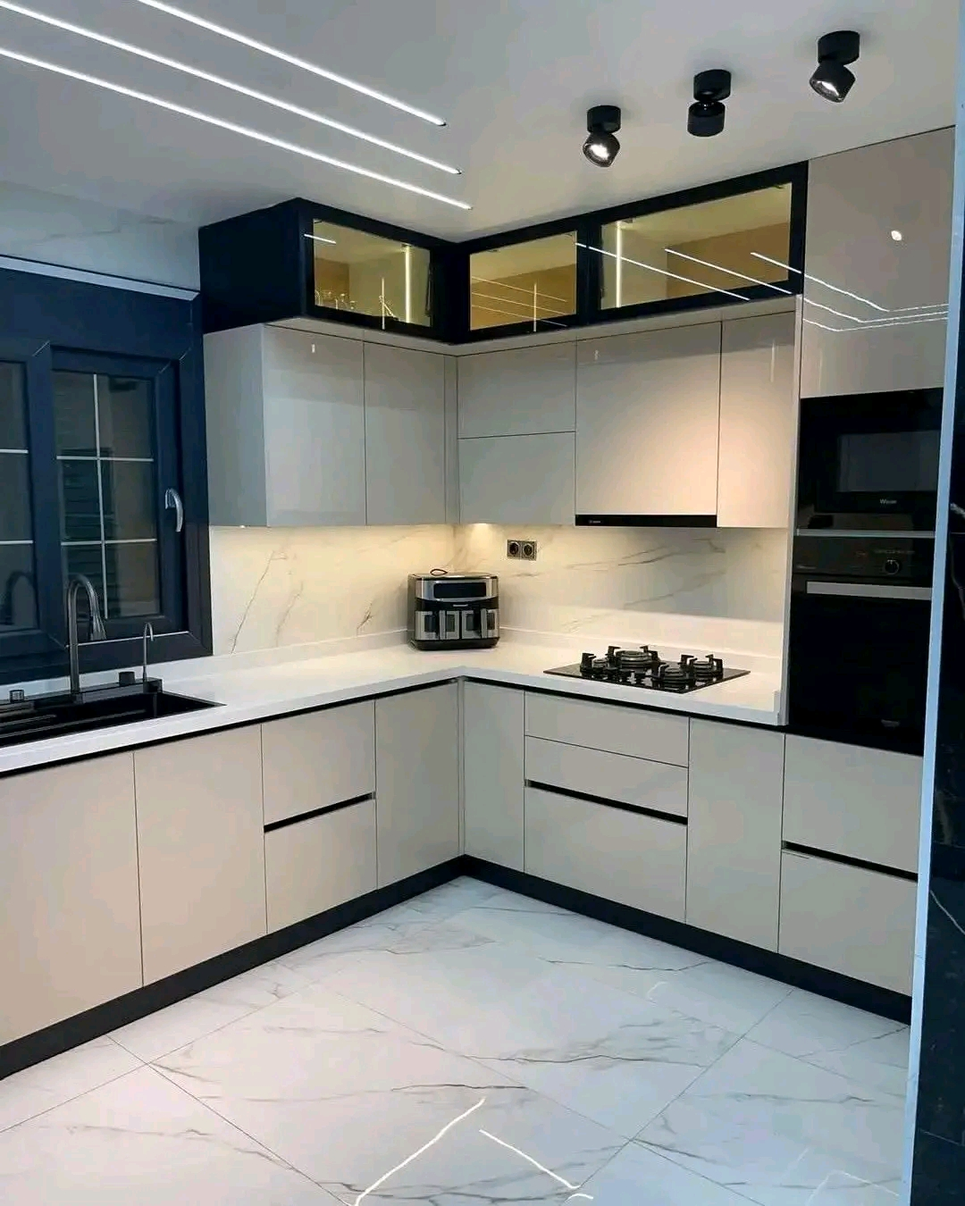 Modern L-shaped kitchen with marble splashback and recessed lighting